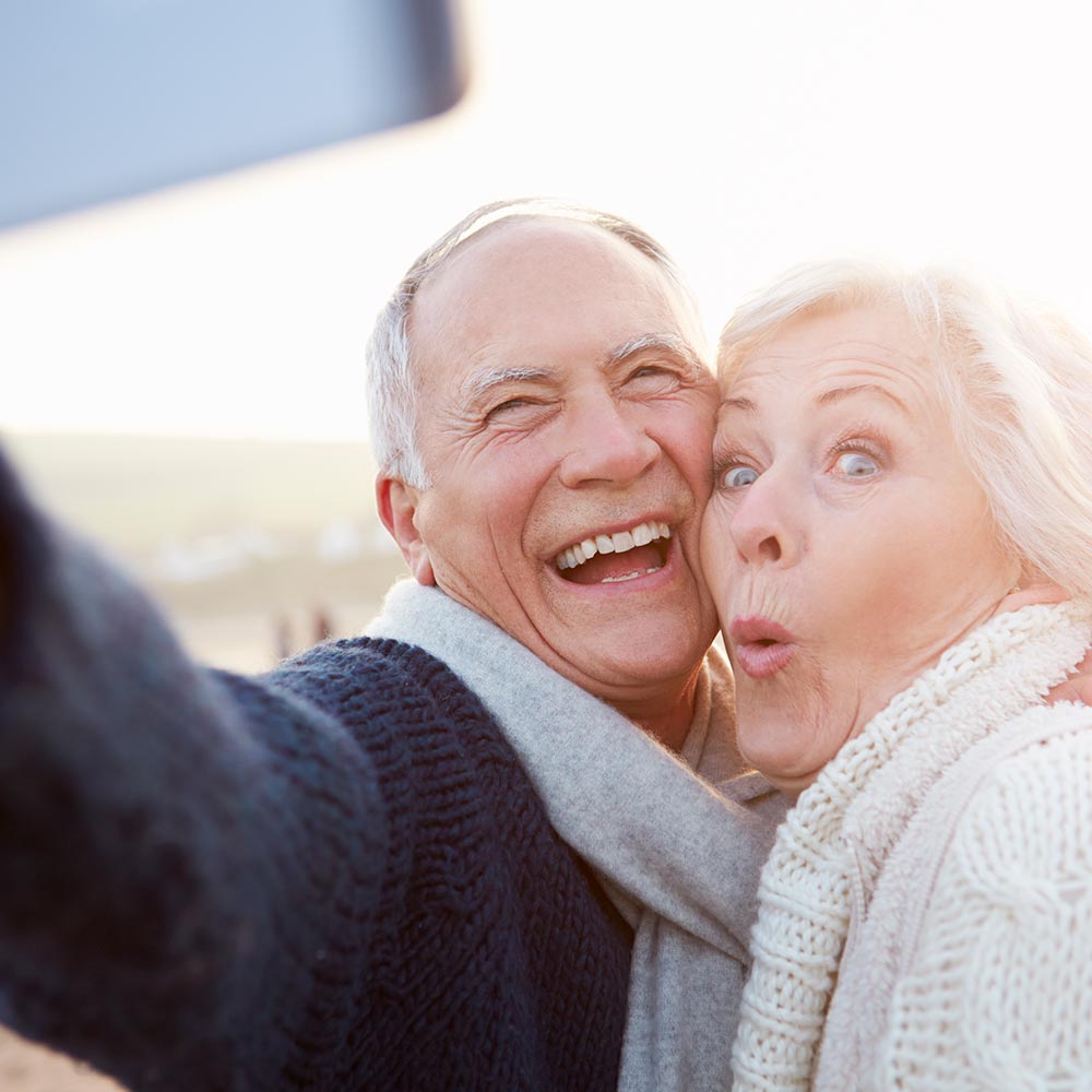 Pareja de adultos mayores muy alegres realizandose una fotografia juntos